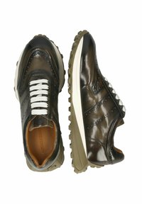 Mörkbruna lädersneakers med vita skosnören. Har brogue-detaljer och en texturerad gummisula med en ljusbrun mellansula.