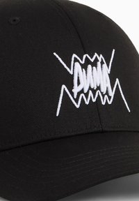 Casquette noire en tissu arborant un logo blanc brodé bien visible avec des accents en zigzag. Visière courbée avec des détails cousus.