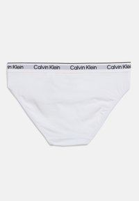 Λευκό γυναικείο σλιπ Calvin Klein με ελαστική μέση με λογότυπο, σε απλό λευκό φόντο.