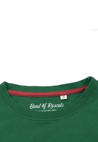Grøn bomulds T-shirt med rund halsudskæring, prydet med en mahogni inderskabelon og hvidt brandlogo tekst. Størrelse mærke synligt indeni kraven.