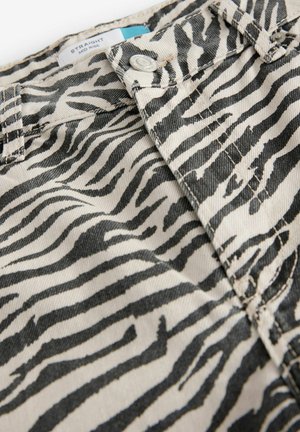 Middenhoog, rechte broek in beige canvas met een zwart zebrapatroon. Inclusief een metalen knoop en stikseldetails.
