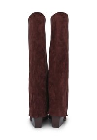 Stivali alti al ginocchio in suede marrone con una texture liscia, tacco a blocco e un design leggermente sformato. Nessun hardware o dettaglio visibile.