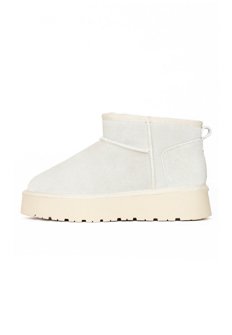 Stivaletto in suede bianco con superficie texturizzata, punta arrotondata e una robusta suola in gomma beige. Dotato di una linguetta sul retro per una facile calzata.