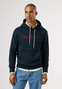 Navyblauwe hooded sweatshirt met witte trekkoorden, een voorkantzak en een rode geborduurde "Pepe Jeans London" logo. Zachte, gestructureerde stof.