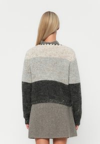 Chunky πλέκτο πουλόβερ με κλίση από μπεζ, γκρι και σκούρο γκρι. Ριμπ γιακάς και μανίκια, κοντή σχεδίαση και υφασμάτινο μοτίβο σε όλη την επιφάνεια.