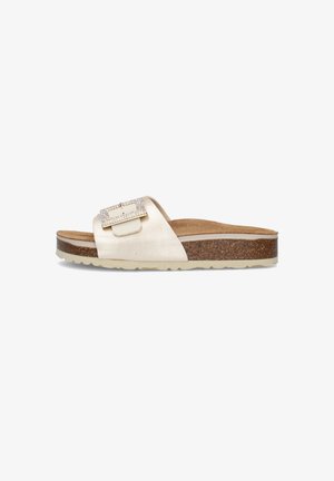 Sandalo slip-on crema con suola in sughero, sottopiede beige, fascia larga con fibbia decorata con strass, su sfondo bianco.