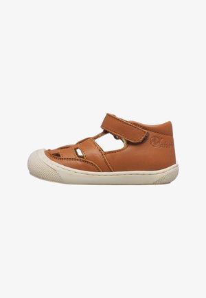 Sandalo per bambino in pelle marrone con suola in gomma bianca, chiusura a strappo e design traforato per traspirabilità e comfort.