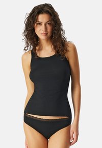 Zwarte tanktop en bijpassende bikinitbroekjes van glad materiaal. De tanktop heeft een ronde halslijn met kant langs de randen.