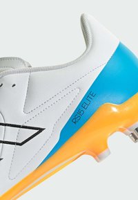 White soccer cleat with a smooth leather upper, blue and orange sole, and black logo detail. Features lace closure and textured accents.