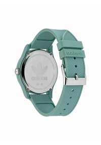 Montre Adidas avec un bracelet en silicone vert menthe, surface texturée, dos de boîtier en acier inoxydable et boucle en métal avec logo.
