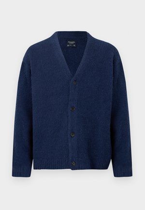 Tamsiai mėlynas vilnonis kardiganas su V formos iškirpte, ilgomis rankovėmis, ribotais rankogaliais ir apačia bei keturiomis juodomis sagomis priekyje.