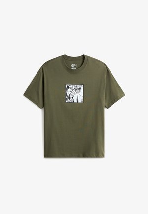 Camiseta Vans verde oliva con gráfico de estilo cómic que muestra a dos personas, una señalando la palabra "Vans" escrita en la espalda de la otra.