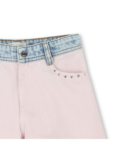 Lichtroze jeans met een licht denim tailleband, zilveren studs op de voorkant van de zak en zichtbare stiksels langs de randen.