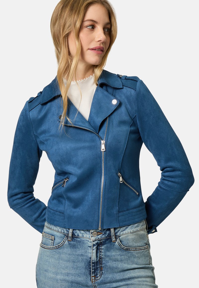 Giubbotto da motociclista blu in suede sintetico con colletto a contrasto, chiusura con zip, doppie tasche laterali e finitura testurizzata. Indossato sopra una maglietta bianca.