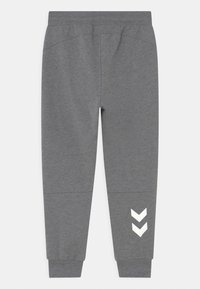 Gray sweatpants with an elastic waistband, tapered cuffs, and white chevron logo detail on the left leg. Made from soft cotton blend material.