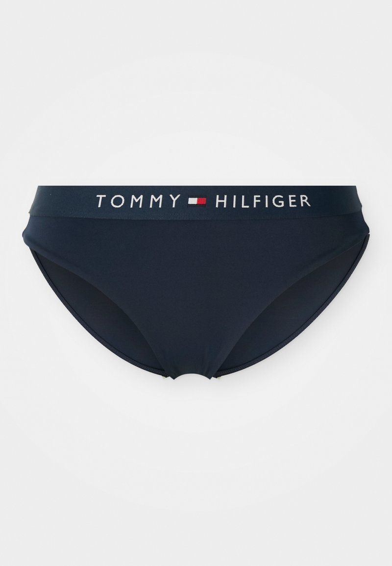 Námornícke modré plavky s širokým elastickým pásom s názvom značky "TOMMY HILFIGER" v kontrastnej bielej a červenej farbe.