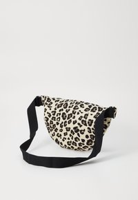 Leopardo rašto maišas, pagamintas iš audinio, turi pusapvalę formą, juodą dirželį ir kontrastingą šviesų foną, pabrėžiantį gyvūnų raštą.