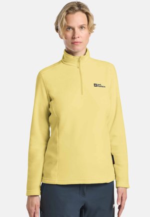 Gelbes Fleece-Pullover mit hohem Kragen, Reißverschluss vorne und gesticktem Logo. Glatte Textur, lange Ärmel und lockere Passform.