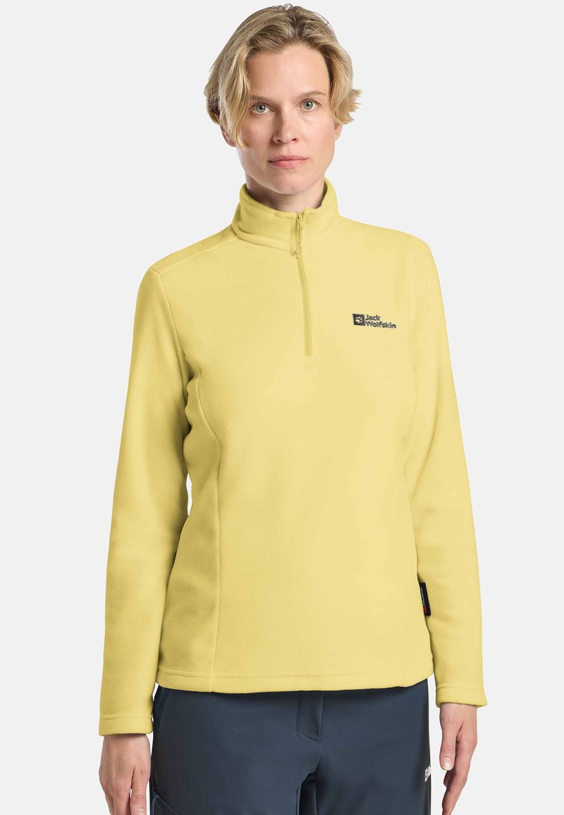 Gelbes Fleece-Pullover mit hohem Kragen, Reißverschluss vorne und gesticktem Logo. Glatte Textur, lange Ärmel und lockere Passform.
