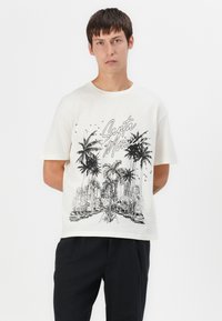 Kremfarget bomulls t-skjorte med svart grafisk design av palmer og en bysilhuett med teksten "Santa Monica". Avslappet passform, kortermet.