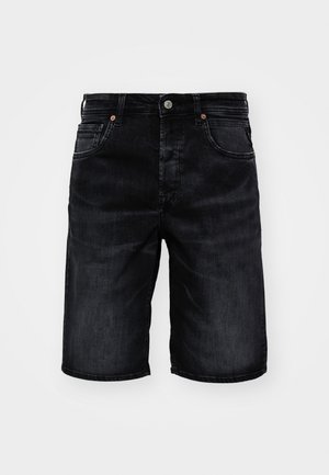 Fekete farmer rövidnadrág egyenes szabással, öt zsebbel és réz kiegészítőkkel. Simább textúra, fehér háttér előtt bemutatva.