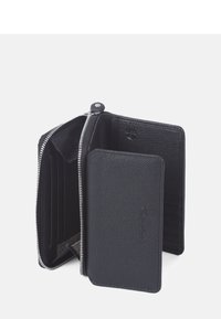 Svart läderplånbok med dragkedja som har flera kortfack, en strukturerad yta och ett tygfoder med ett subtilt mönster.