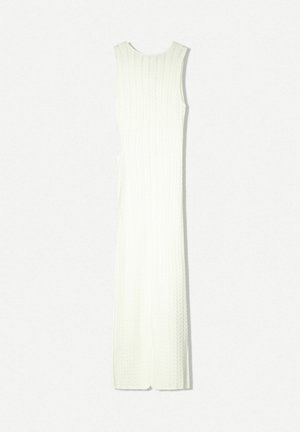 Abito lungo bianco a costine, senza maniche, con una silhouette aderente e spacchi laterali. Realizzato in un tessuto testurizzato che crea un motivo sottile.