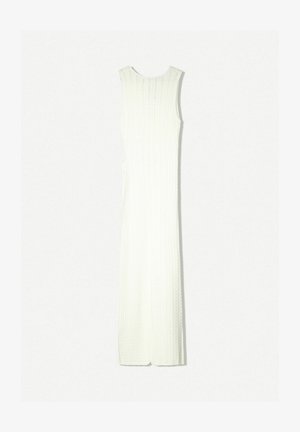Robe longue blanche côtelée sans manches avec une silhouette ajustée et des fentes latérales. Fabriquée dans un tissu texturé créant un motif subtil.