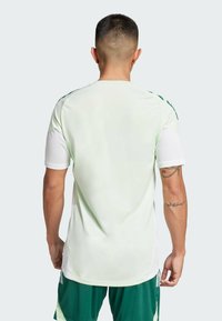 Maglietta sportiva verde chiaro a maniche corte, con un design posteriore senza cuciture e accenti verdi a contrasto sulle spalle.