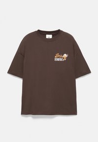 T-shirt marron à manches courtes avec un petit graphique d’un astronaute de dessin animé et les mots "Buzz Lightyear" sur la partie supérieure gauche de la poitrine.