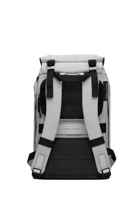 Sac à dos gris avec des accents noirs, conçu avec des bretelles rembourrées, un fermeture à enroulement et des détails en maille dans le dos pour la ventilation.