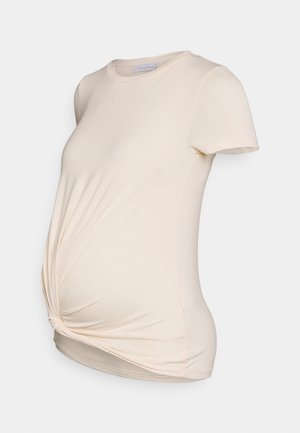 Crèmekleurig zwangerschaps-T-shirt met korte mouwen, een gedraaide voorkant en een ronde halslijn op een egale achtergrond.