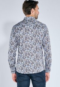 Langärmliges Hemd aus gemustertem Stoff mit blauem, grauem und weißem Paisleymuster, mit Knopfkragen und abgerundetem Saum.