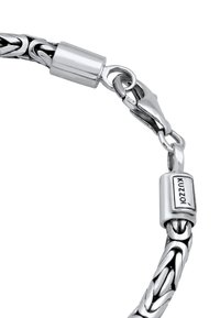 Bracelet made of interwoven silver links with a polished finish. Features a lobster clasp and engraved brand label. Sleek, smooth texture.