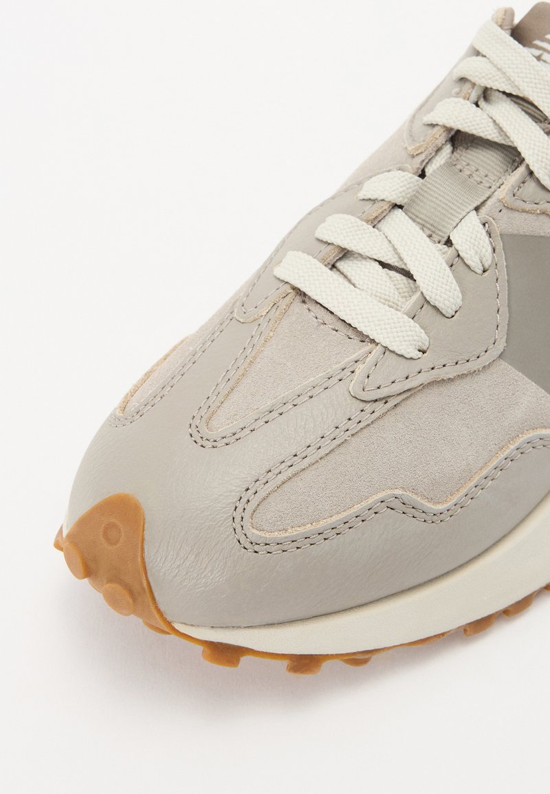 Hellgraue Leder- und Wildledersneaker mit strukturierten Akzenten und beiger Gummisohle. Verfügt über flache Schnürsenkel und ein schlankes Design.
