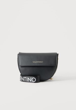 Crna Valentino crossbody torba u obliku polumjeseca s preklopnim zatvaračem i istaknutim remenom s bijelim slovima na crnoj pozadini.
