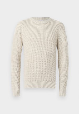 Pull en tricot de couleur crème avec une texture côtelée, col rond et manches longues. Présente une coupe ample et des poignets et un ourlet élastiques.