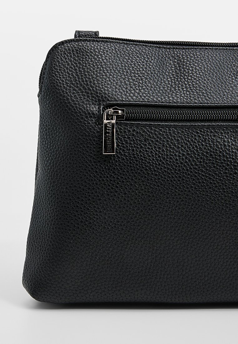 Schwarze, strukturierte Lederhandtasche mit einem Reißverschlussfach, glatten Hardware-Akzenten, rechteckiger Form und sanfter Oberfläche.
