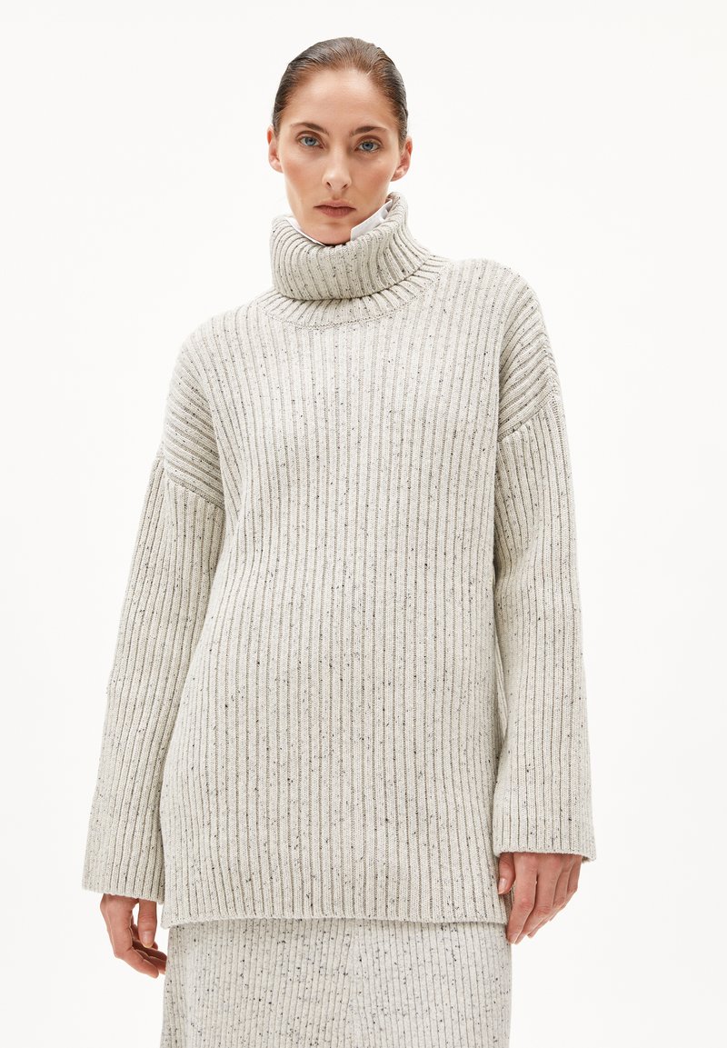 Hellgrauer, gerippter Rollkragenpullover mit lockerer Passform und weiten Ärmeln. Der strukturierte Stoff hat subtile Sprenkel, die das visuelle Interesse erhöhen.