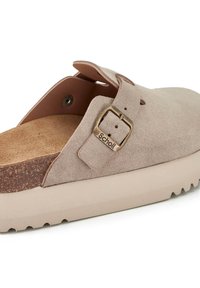 Scarpa slip-on in suede beige con soletta in sughero, dettaglio della fibbia in tono oro e suola in gomma testurizzata per grip e supporto.