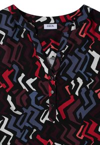 Schwarz-weiße Bluse mit Knopfleiste aus Stoff, mit einem mehrfarbigen abstrakten Muster, das rote, blaue, weiße und kastanienbraune Formen zeigt. Etikett trägt "CECIL."