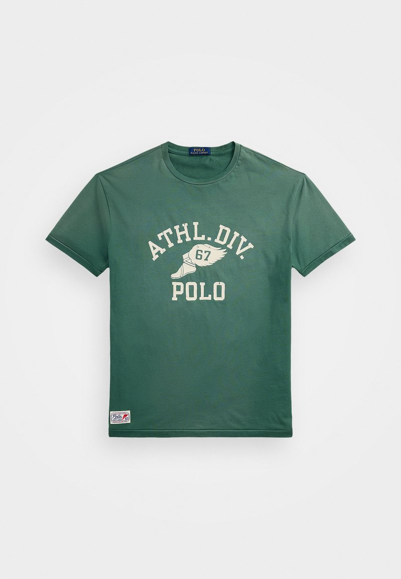 T-shirt en coton vert foncé à manches courtes. Présente un texte crème "ATHL.DIV. 67" et un détail de logo sur l'ourlet gauche.