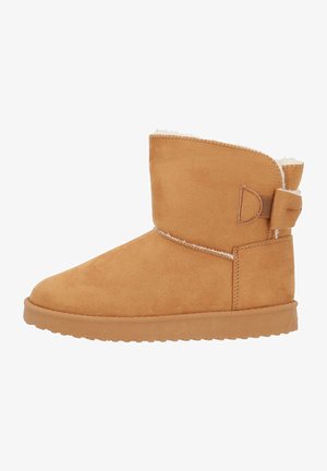 Tan suède enkellaars met een zachte, witte bontvoering, voorzien van een zijband en een gestructureerde rubberen zool voor grip.