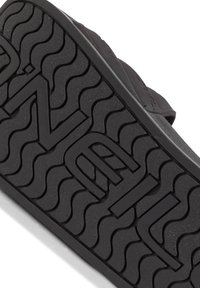 Sort gummisål til sandaler med struktureret bølgen mønster og stort præget logo. Designet fokuserer på greb og holdbarhed til fodtøj.