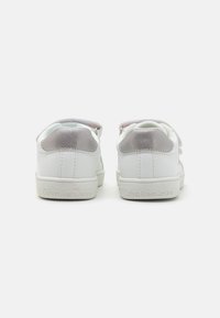 Baskets en cuir blanc avec une texture lisse, accents gris au talon, et une semelle en caoutchouc blanc arborant la marque "Calvin Klein Jeans".