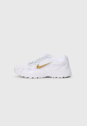 Weißer Sportschuh mit goldenem Nike-Swoosh, Obermaterial aus Mesh und Synthetik, gepolsterter Sohle und "P-6000" Schriftzug nahe der Ferse.