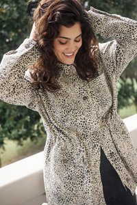 Leopard print shirt jacket in beige and black, featuring a button-up front, chest pocket, and relaxed fit with wrist cuffs. Textured fabric.