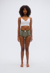 Λευκό crop top συνδυασμένο με εσώρουχο σε χακί πράσινο με ριγέ οριζόντια λευκά και μικρή ετικέτα με λογότυπο.