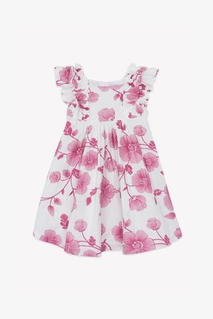 Valkoinen mekko, jossa vaaleanpunainen kukkakuosi ja röyhelöiset olkaimet. Kangas on kevyt, vyötärö nauhoitettu ja helma levenee.