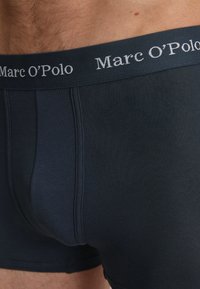 Boxer in navy scuro realizzati in un tessuto morbido. Presentano un morbido elastico in vita con il logo "Marc O'Polo" in lettere grigie.